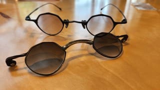 two pairs of thin-framed, black eyeglasses