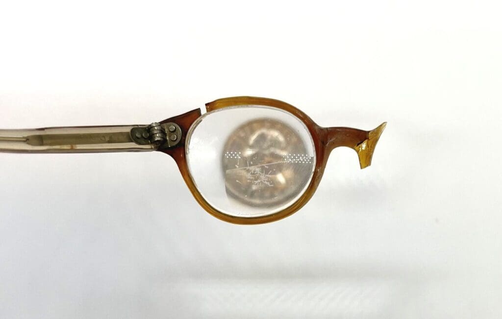 brown and yellow baby glasses, with lenses that are only slightly larger than a quarter